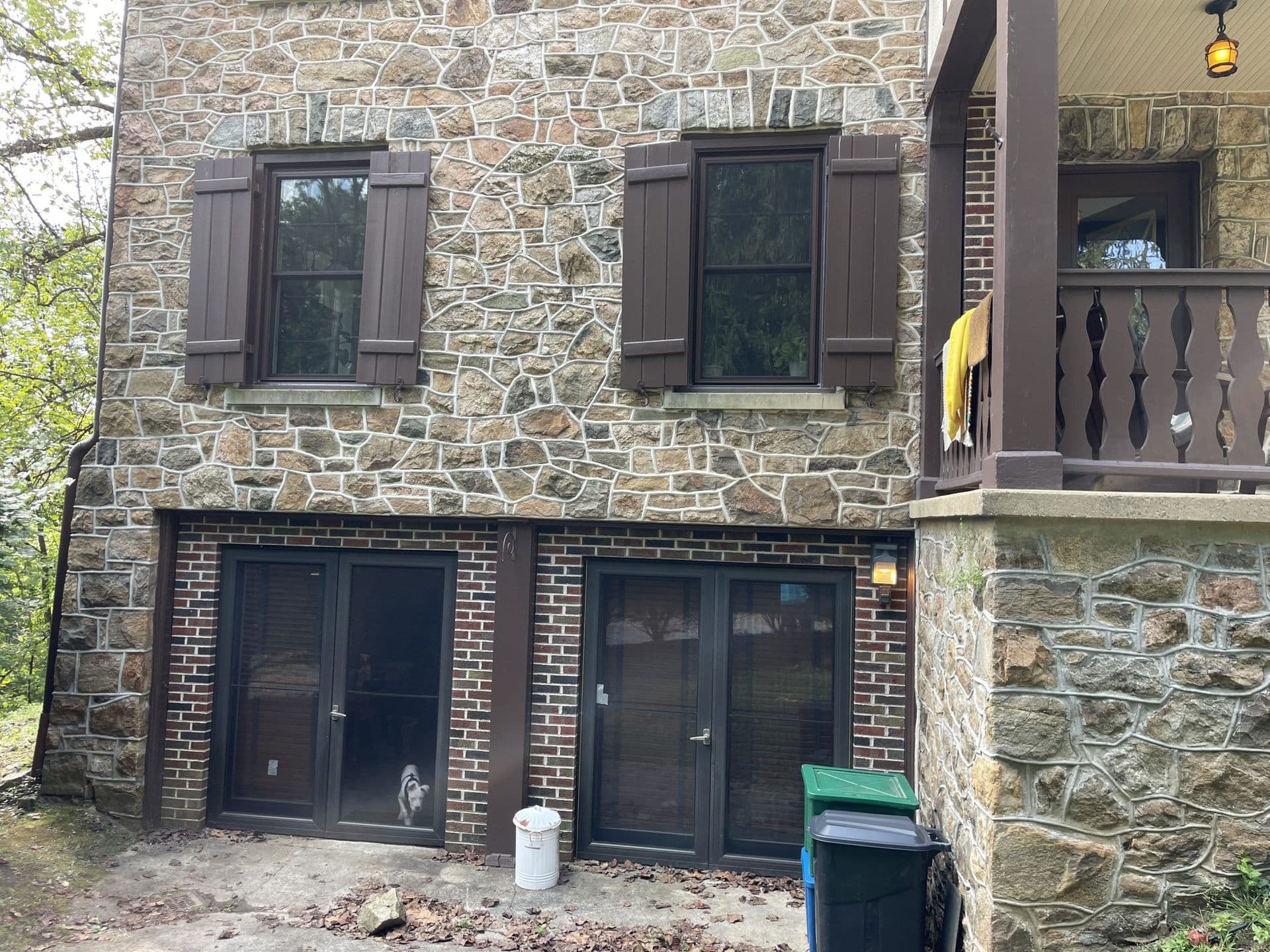 Black-sliding-glass-doors-and-replacement-windows-with-brown-shutters