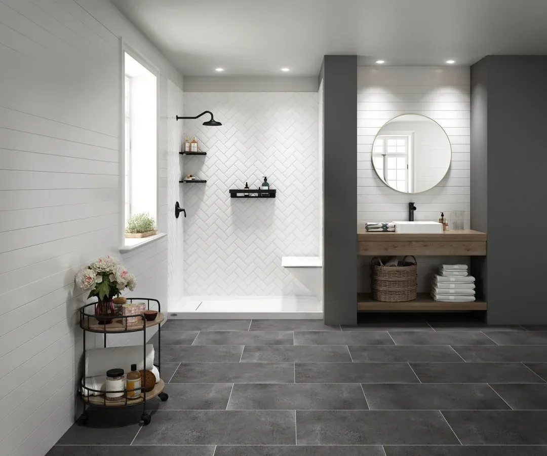 Modern bathroom with walk-in shower, floating vanity with round mirror, dark gray tile flooring, white subway tiles, and black fixtures